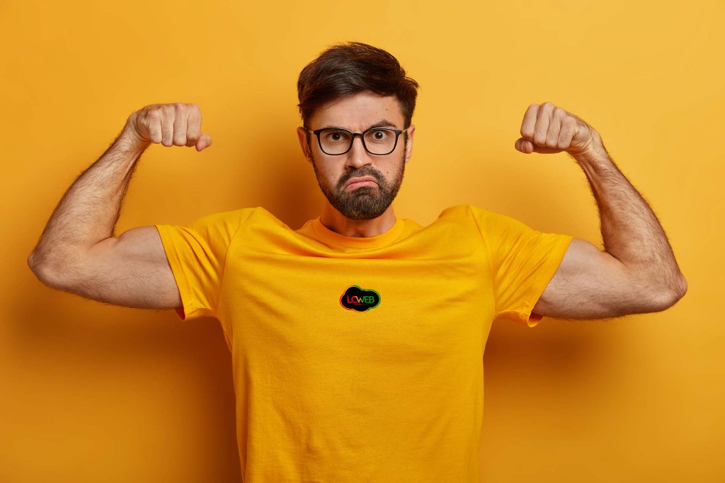Membre de l’équipe LCWEB, pose dynamique sur fond jaune avec le logo LCWEB sur le t-shirt